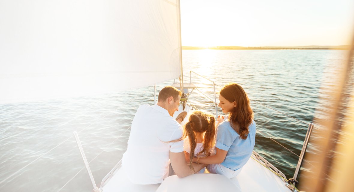 Familie mit Kind auf einem Boot in See stechend bei Sonnenlicht